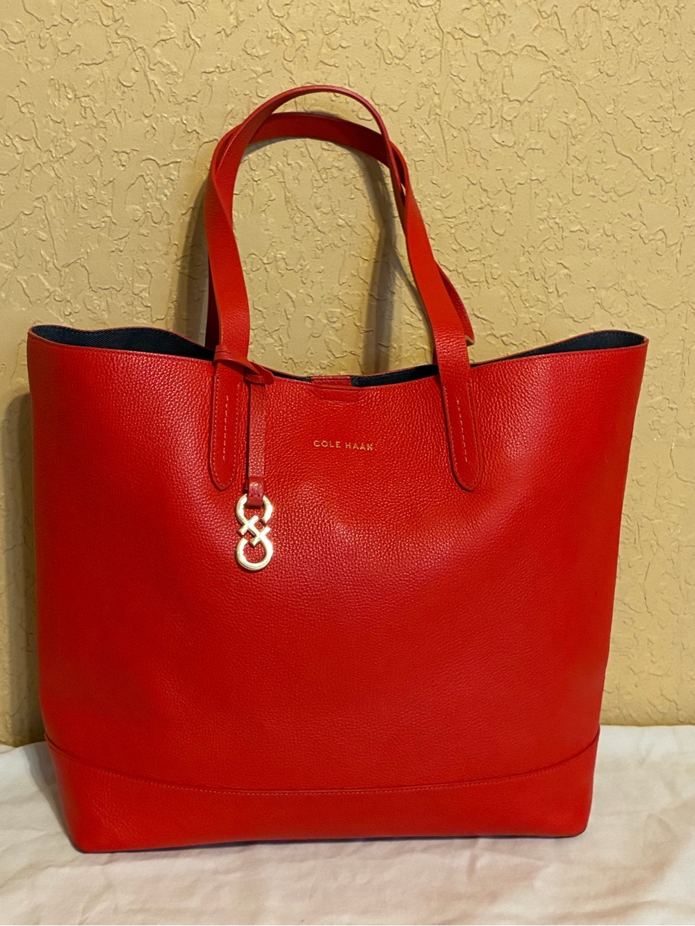 Cole Haan Red Leather tote bag featuring pebbled texture and gold-toned hardware